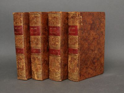 trois vieux livres empilés les uns sur les autres sur une surface grise