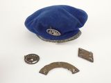 a blue hat and some metal buttons on a white surface