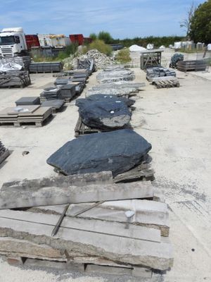 many pieces of concrete sitting on the ground in a parking lot