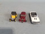three toy cars sitting next to each other on a table