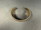 a close up of a gold ring on a metal surface