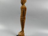 a wooden statue of a man standing on a wooden base