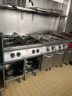 a kitchen with a stove, oven, sink, and other appliances