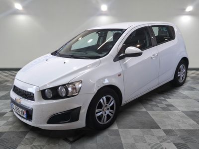 the white car is parked in the room on the checkered floor