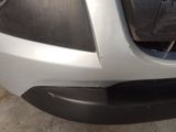 the front bumper of a silver car with a black bumper cover