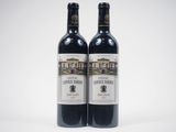 two bottles of red wine sitting next to each other on a white surface