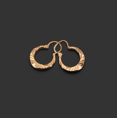 une paire de boucles d'oreilles en or sur fond noir