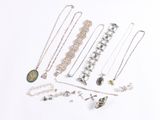 a lot of necklaces and bracelets on a white surface