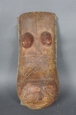 gros plan d'un masque en bois sur une surface grise