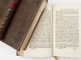 a book with a pen on top of it next to an open book