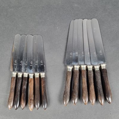 six knives are lined up on top of each other on a table