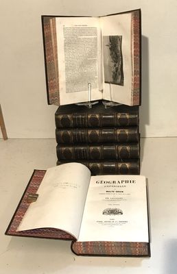 a book open on a table next to a stack of books