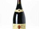 la bouteille de vin rouge est posée sur une surface blanche