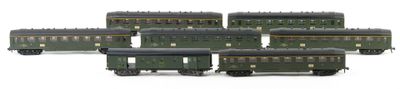 several green train cars are lined up on a white surface