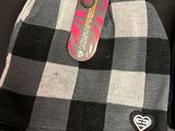 a black and white checkered beanie and a pair of pink flip flops