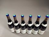 six bottles of wine are lined up in a row on a table