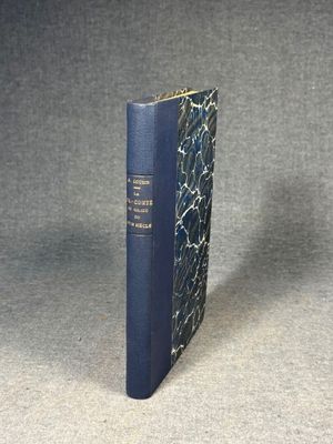 a blue book sitting on top of a table next to a gray wall