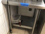 une petite cuisine avec un plan de travail en inox et un micro-ondes
