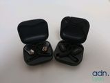 two black earphones in a black case on a white surface