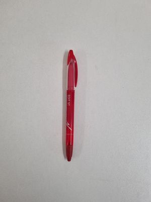 a red pen sitting on top of a white surface