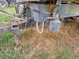une remorque rouillée garée dans l'herbe