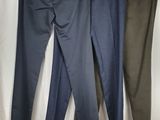 three men ' s pants hanging on a clothes rack in front of a white curtain