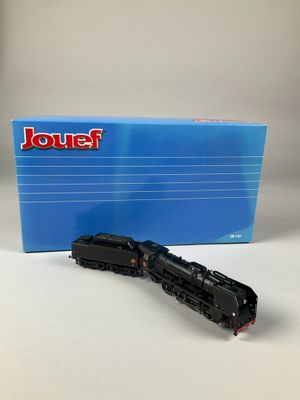 un gros plan d'un petit train miniature posé sur une table près d'une boîte
