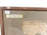 an old suitcase with a label on it sitting on a table