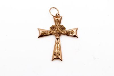 gros plan d'une croix en or sur fond blanc