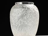 a glass vase with a design on it on a table