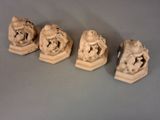 trois petites statues représentant un homme et une femme assis l'un sur l'autre