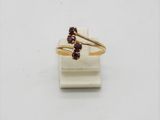 un gros plan d'une bague en or sertie de deux grenats