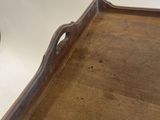 an antique wooden tray with handles and handles on a table
