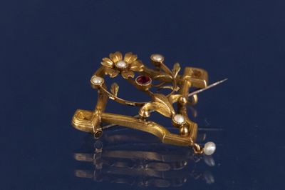 une image représentant une broche en or ornée de fleurs et de perles