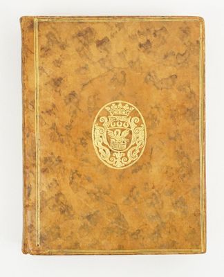 un vieux livre avec un emblème en or sur la couverture