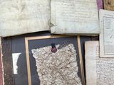 several old books are sitting on a pink cloth covered table