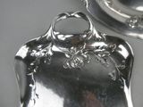 a silver plate with a handle on it and a silver plate with a handle on it
