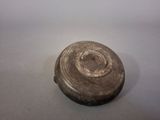a small metal object on a table with a white background