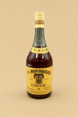 une bouteille de cognac posée sur une surface marron