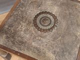 a small table with a clock on it on a wooden floor
