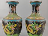two vases with dragon designs on them sitting on a table