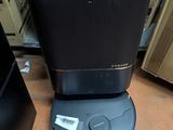 a black speaker sitting on top of a table next to boxes