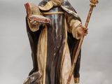 figurine représentant un homme tenant un livre et un bâton