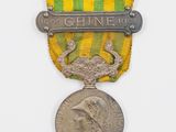 une image représentant une médaille entourée d'un ruban, avec une médaille au centre