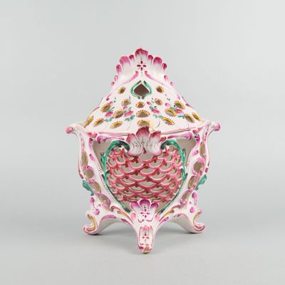 un vase rose et vert posé sur une table blanche