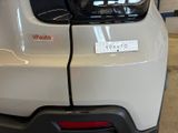 the rear end of a white car with a sticker on it ' s bumper