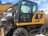 a picture of a cat excavator parked in a yard