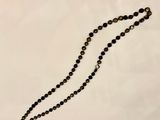 a close up of a beaded necklace on a white surface