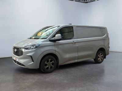 une camionnette argentée garée dans une pièce blanche au sol noir