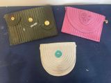 three purses are lined up on a blue surface with buttons